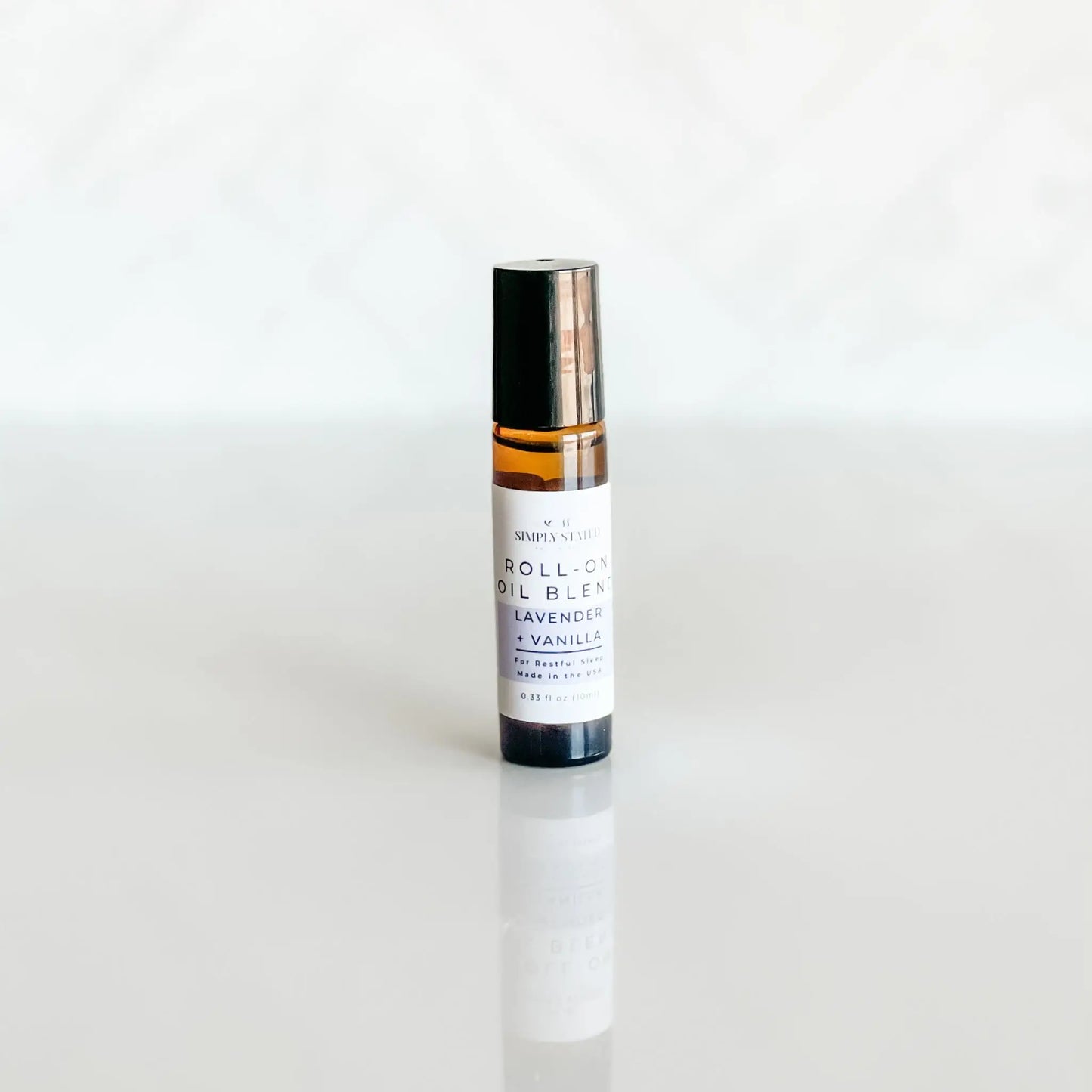 Roll-on oil blend bottle with lavender and vanilla on a white background
