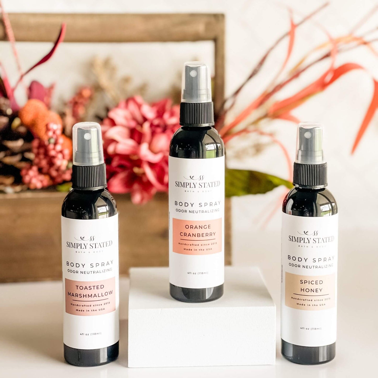 Simply Stated Fall Body Spray Collection in front of fall floral arrangement