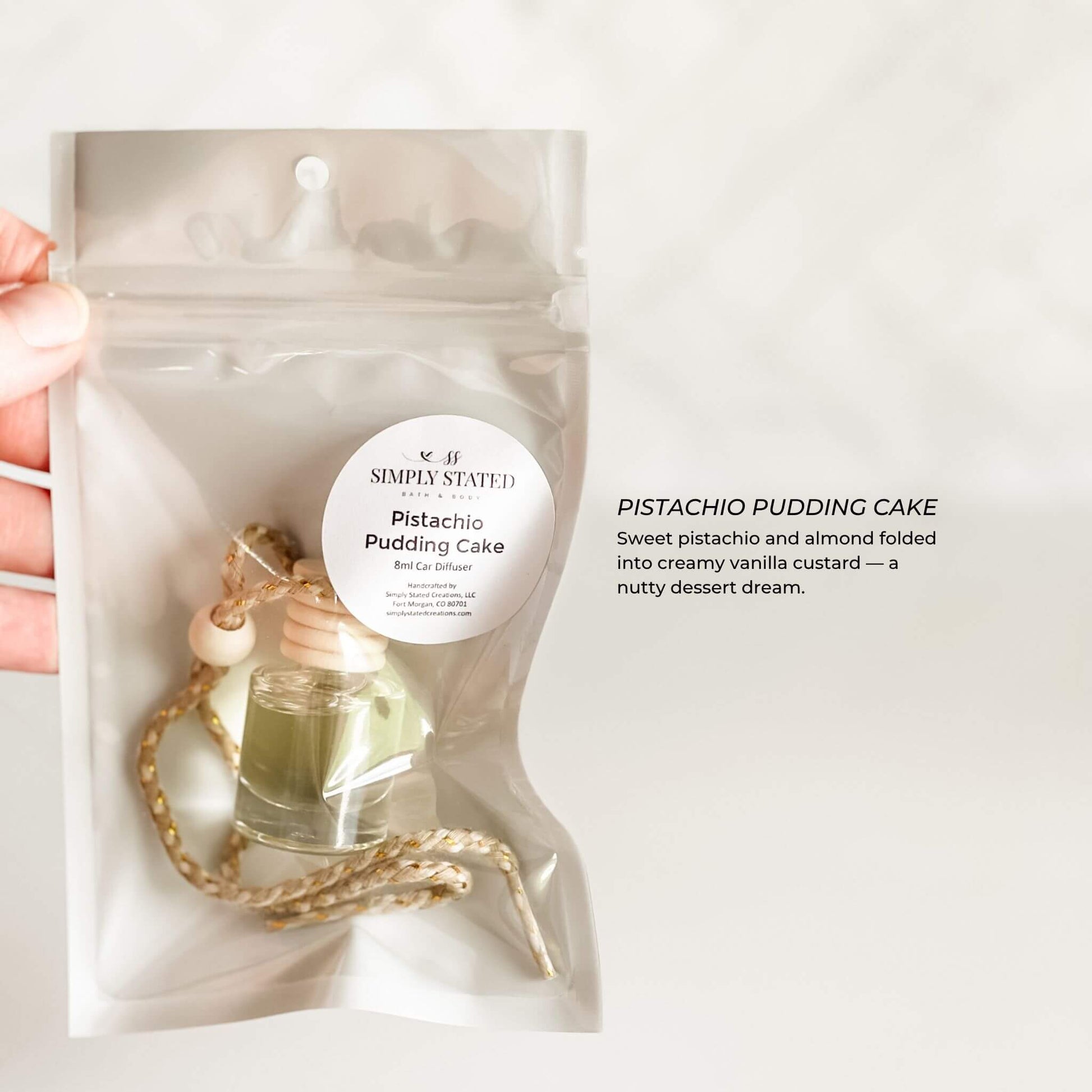 Pistachio pudding cake package held by a hand on a white background