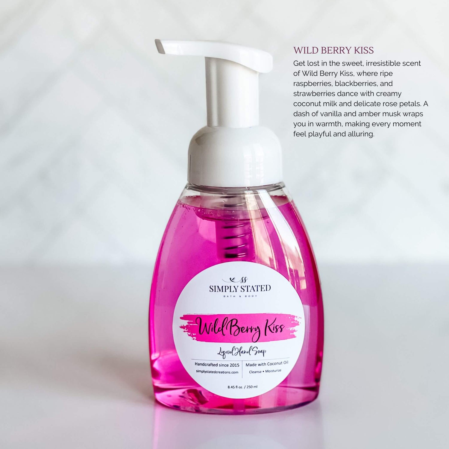 Simply Stated Bath & Body Wild Berry Kiss Liquid Hand Soap in a clear pump bottle with soft pink soap, featuring a magenta label, displayed on a clean white background.