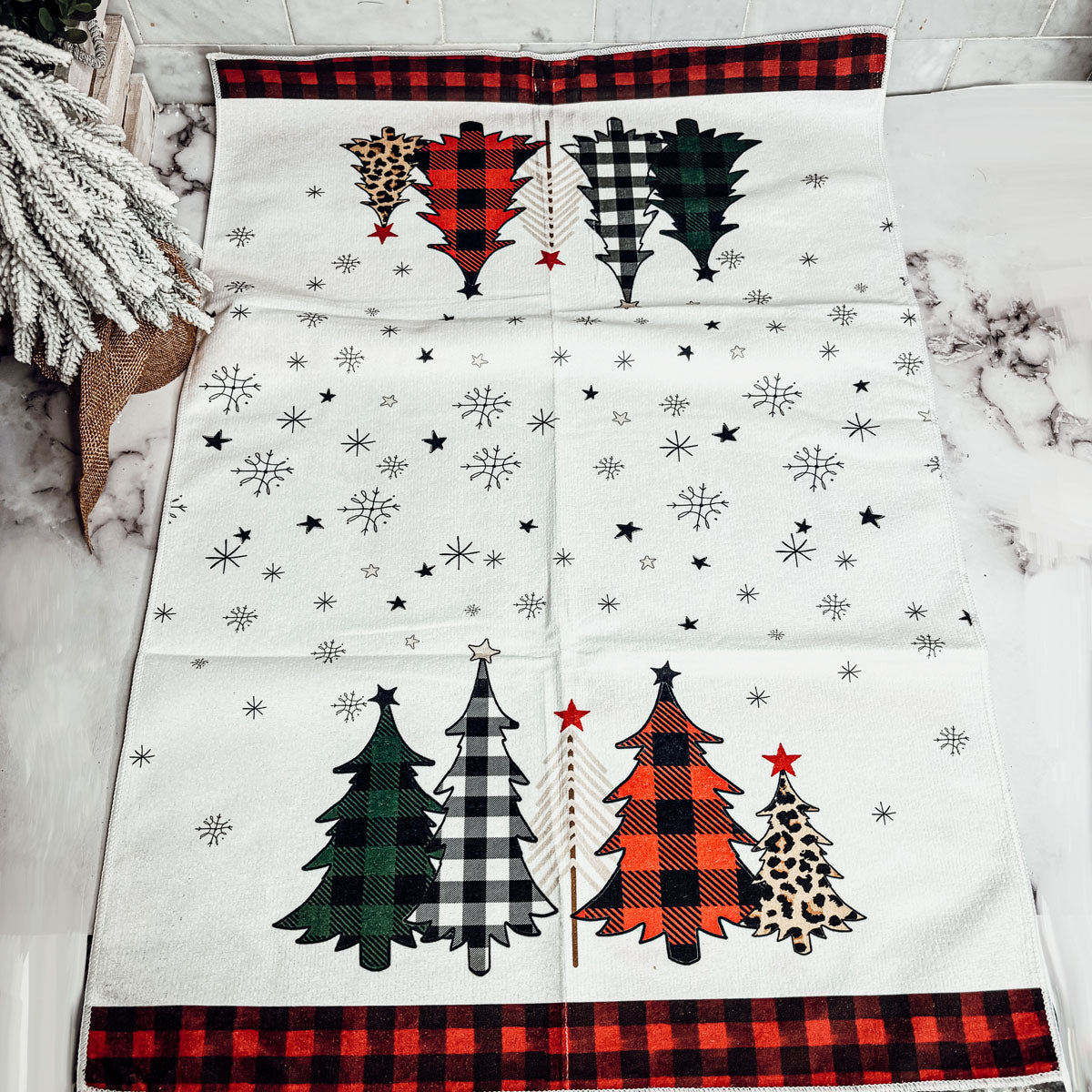 Christmas hand towel featuring colorful gingham tree designs and snowflakes
Rustic holiday dish towel with red black gingham ends and festive winter decor