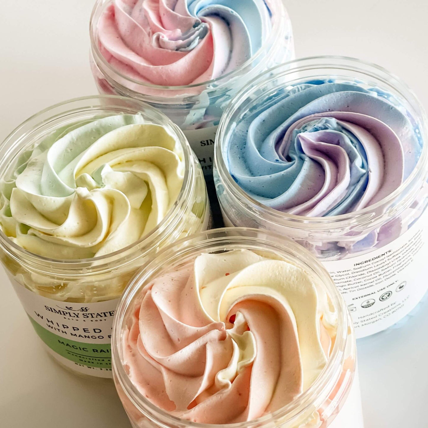 A lineup of colorful whipped soaps with swirled pastel hues, perfect for gentle cleansing and fun bath time.