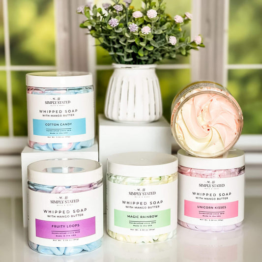A collection of Simply Stated Bath & Body's Kids Whipped Soap in fun, vibrant swirls, featuring Cotton Candy, Fruity Loops, Magic Rainbow, Tropical Twist, and Unicorn Kisses.