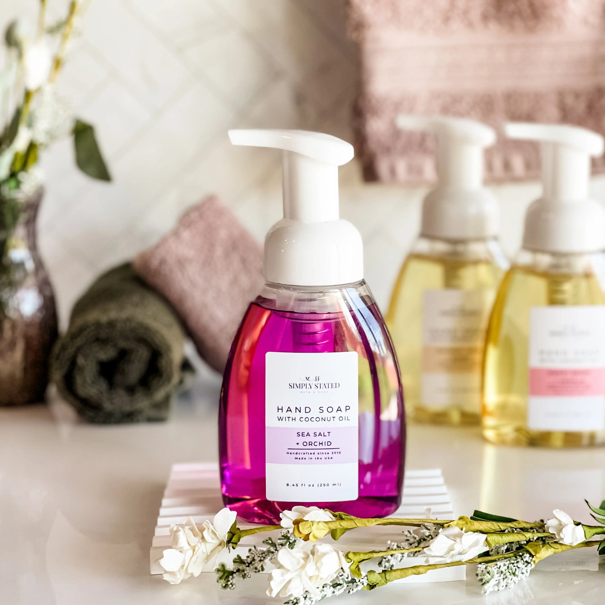 Hand soap bottle with floral arrangement on a table