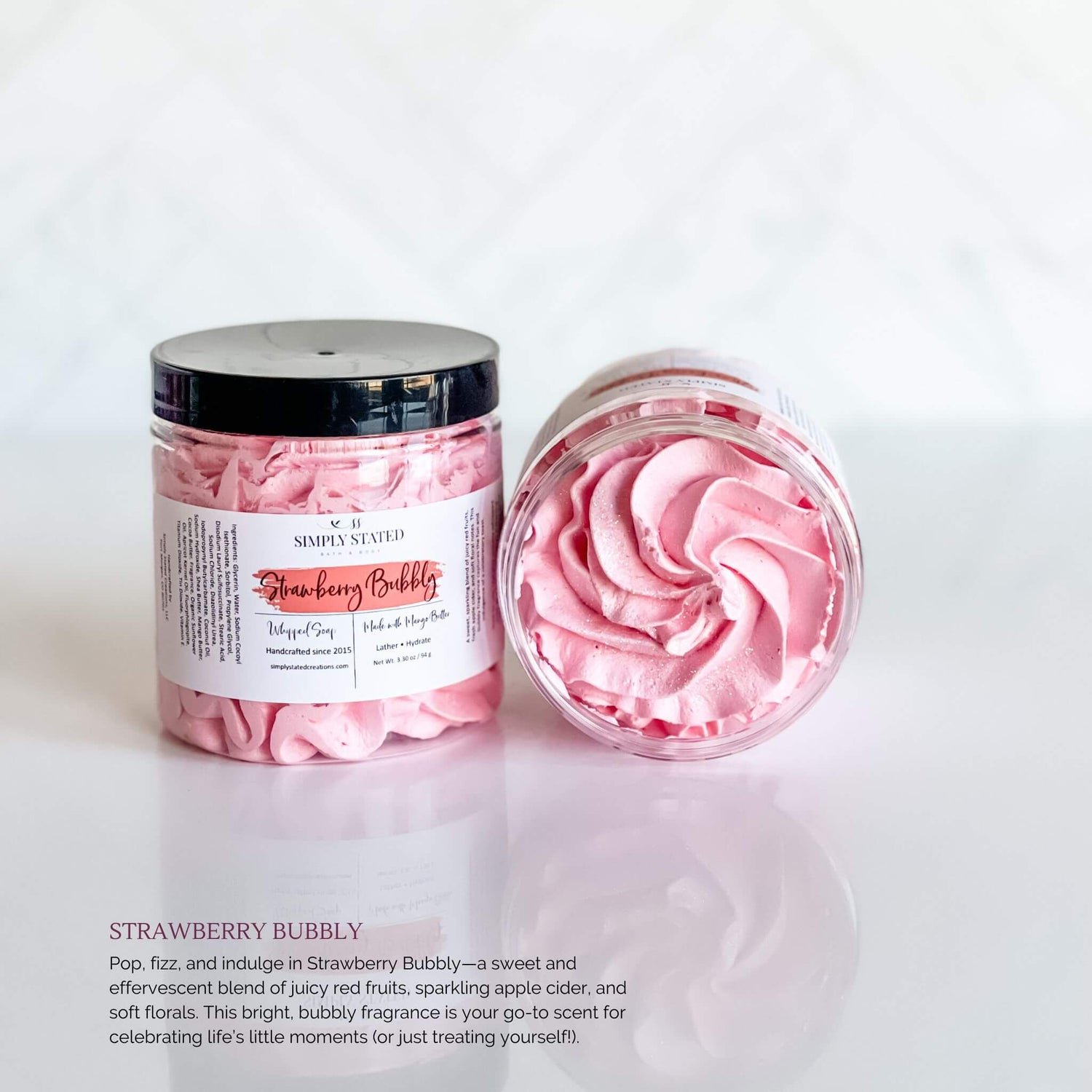 Simply Stated Bath & Body Strawberry Bubbly Whipped Soap in a clear jar with bright pink swirled soap, featuring a pink label and black lid, set against a white background.