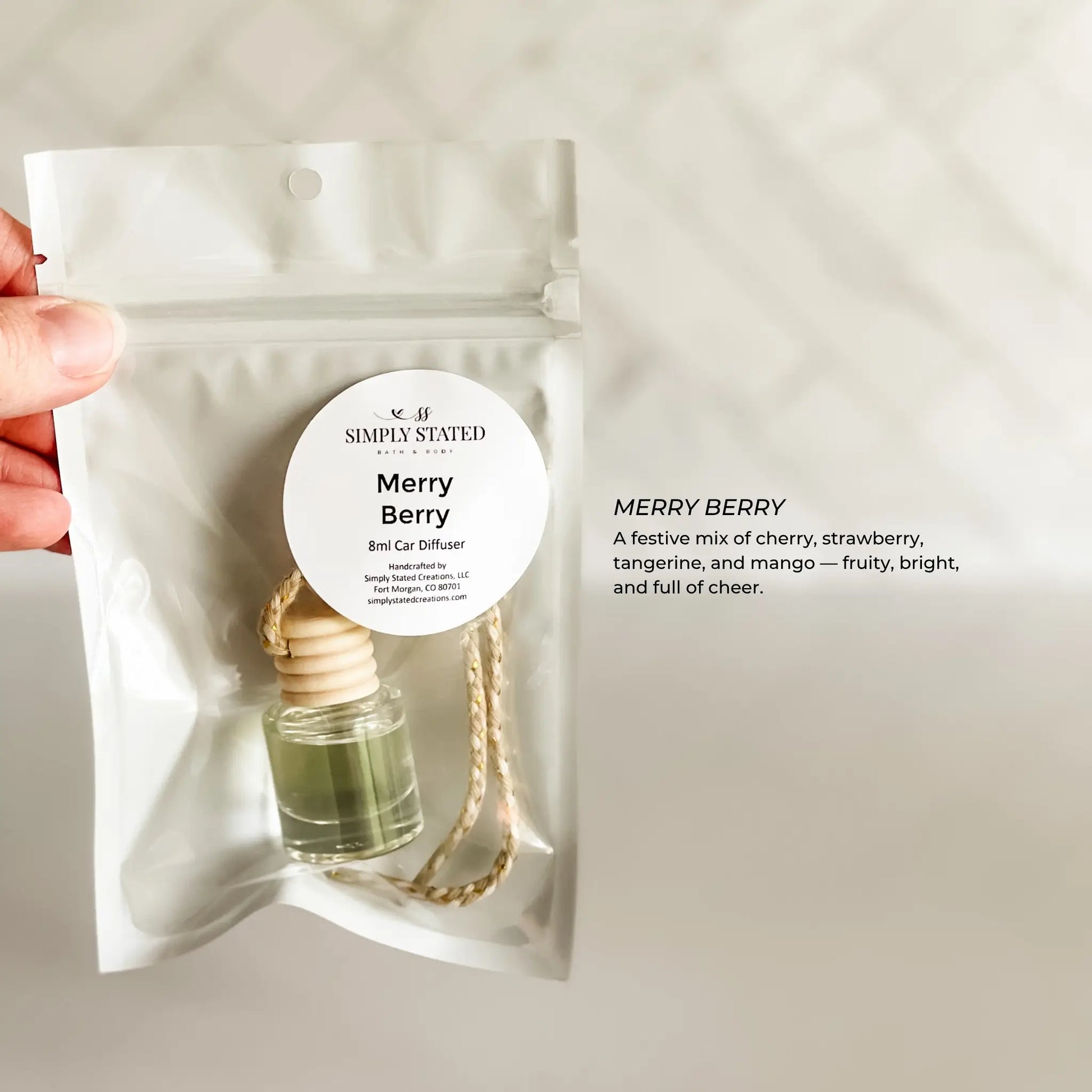 Merry Berry diffuser packaging held by a hand on a light gray background