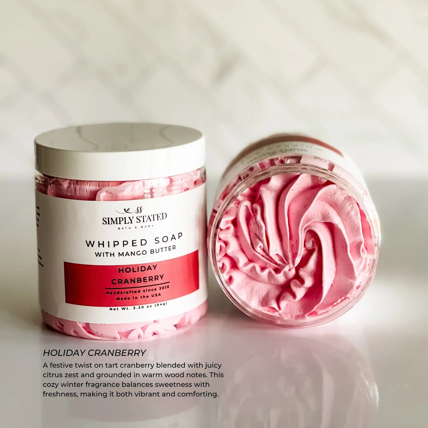 Pink whipped soap with a white container labeled 'Simply Stated' on a light background