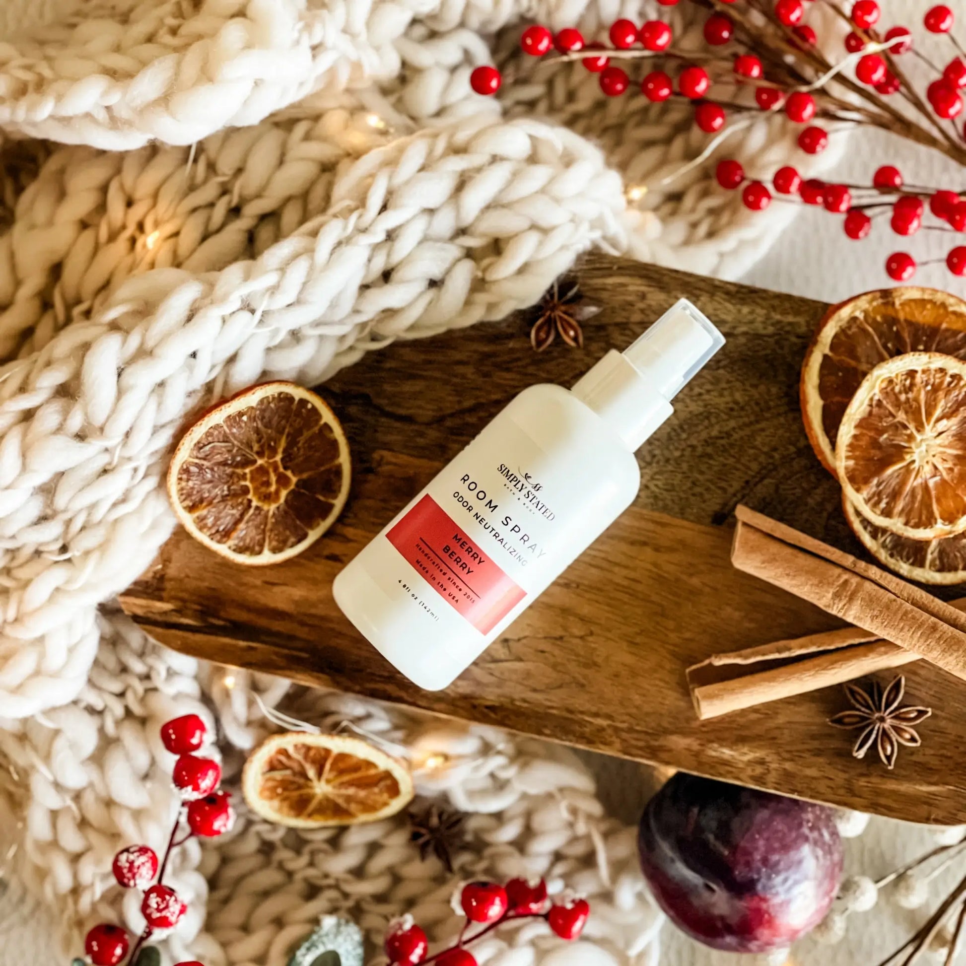 Room spray bottle on a wooden tray with winter decorations
