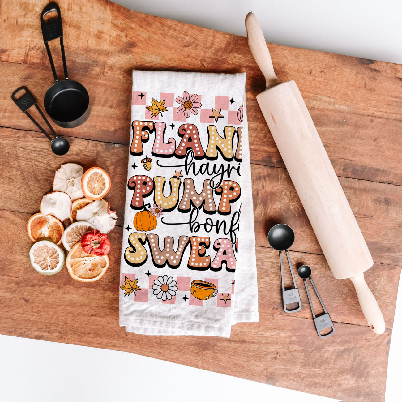 cute fall dish towel for college dorm or first apartment
pink autumn towel with cozy fall words and icons
fall themed cotton tea towel with retro lettering and checkered border
flannels and pumpkins pink retro fall towel on cutting board
pink seasonal kitchen towel perfect for fall and halloween gifting