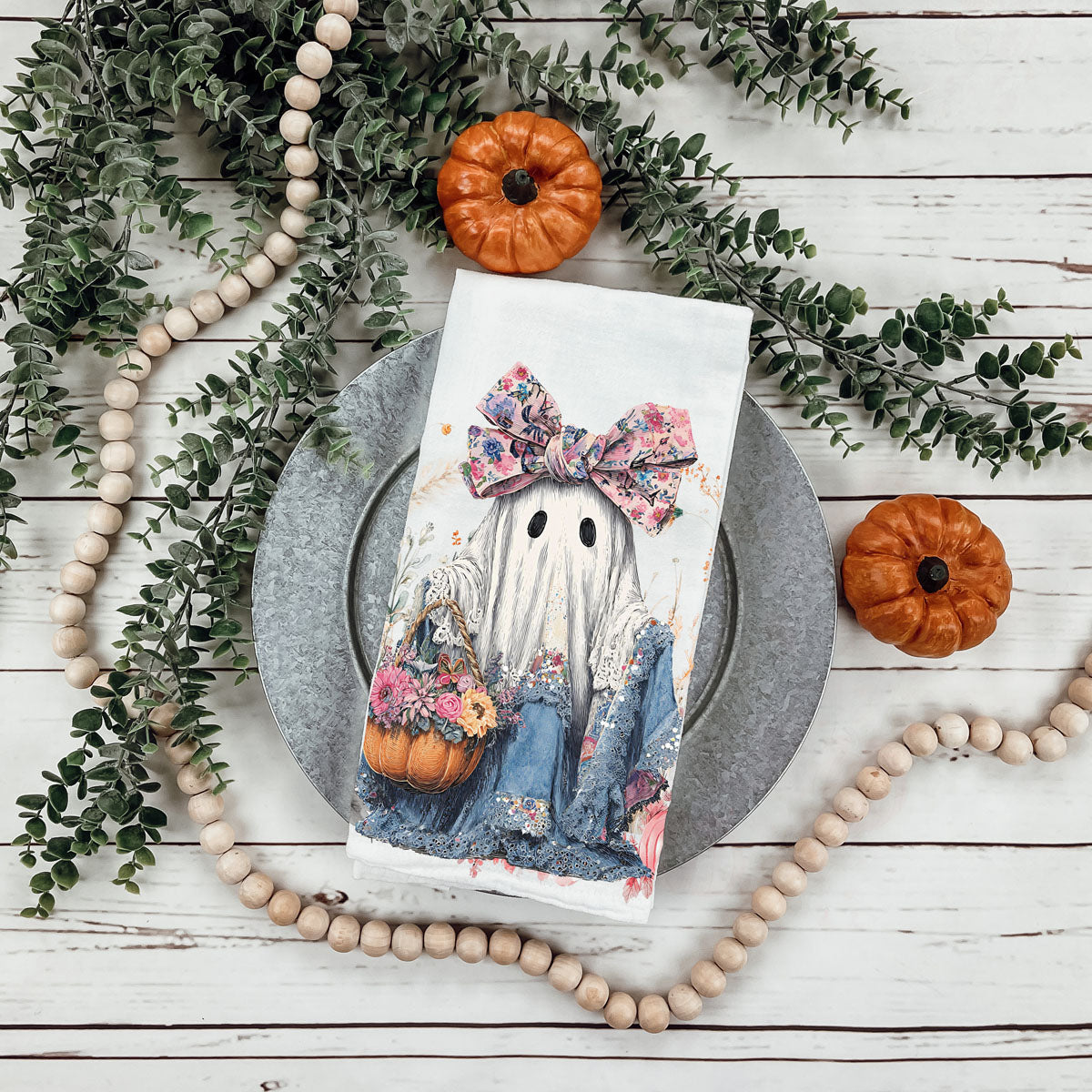 soft pastel halloween tea towel for cozy kitchen
pink farmhouse fall towel with sweet ghost illustration
ghost in denim dress flour sack towel on cutting board
pretty halloween décor towel with flowers pumpkins and ghost