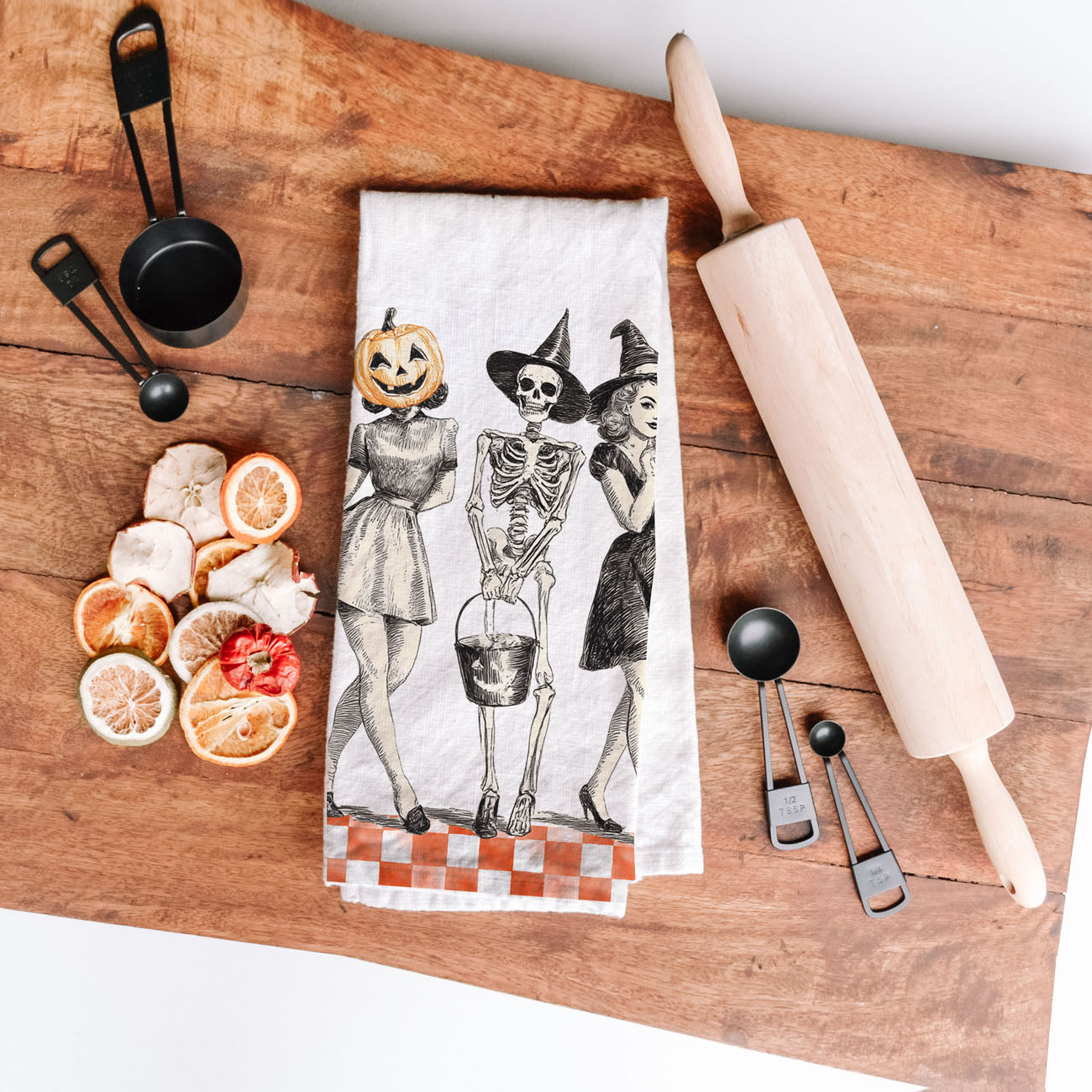 farmhouse halloween kitchen towel with pumpkin head lady
vintage sketch halloween towel with skeleton and witches
old fashioned spooky season towel with orange checks
retro halloween trio towel for fall coffee station