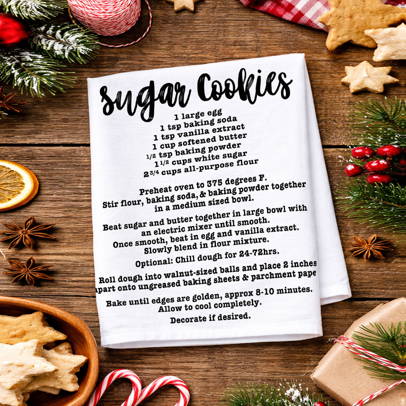 christmas kitchen towel with recipe in cozy home
holiday towel held in front of decorated christmas tree
kitchen towel recipe styled outdoor winter scene
christmas towel styled with lights and garland decor
recipe kitchen towel lifestyle holiday aesthetic