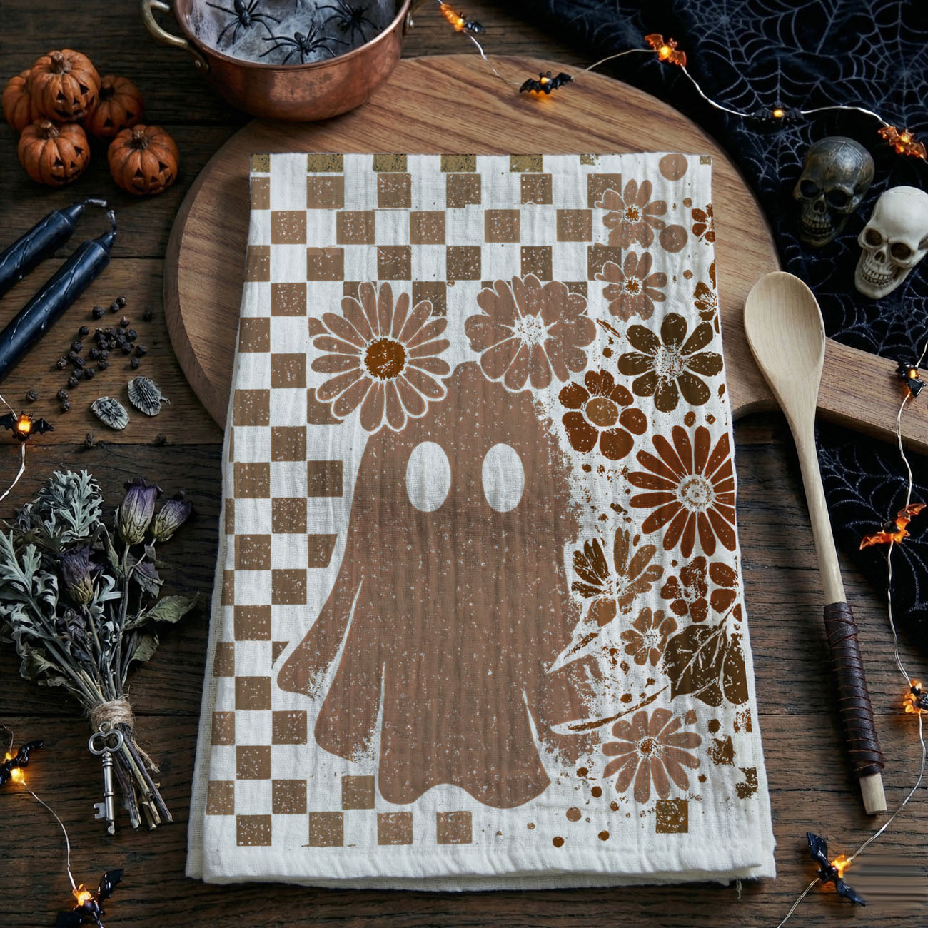 boho fall kitchen towel with skull, flowers and checkerboard
vintage skull and ghost tea towel hanging on oven handle
neutral spooky season towel for minimalist halloween décor